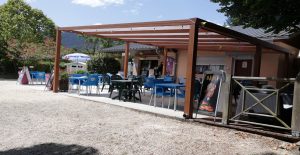 Terrasse du snack-bar du Camping Le Vaugrais en Savoie, idéale pour se détendre et savourer des spécialités locales.