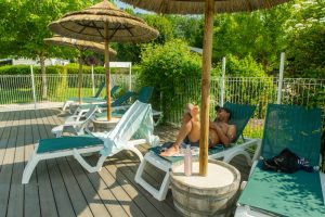 Vacanciers se détendant au bord de la piscine du Camping Le Vaugrais, l’un des meilleurs campings en Savoie.