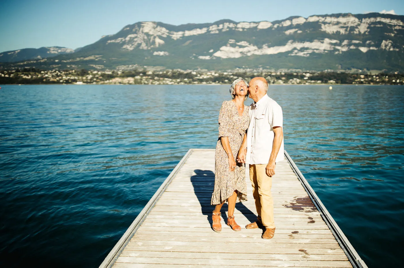 Couple âgé se détendant sur un ponton au bord du Lac du Bourget, profitant du calme et de la beauté naturelle.