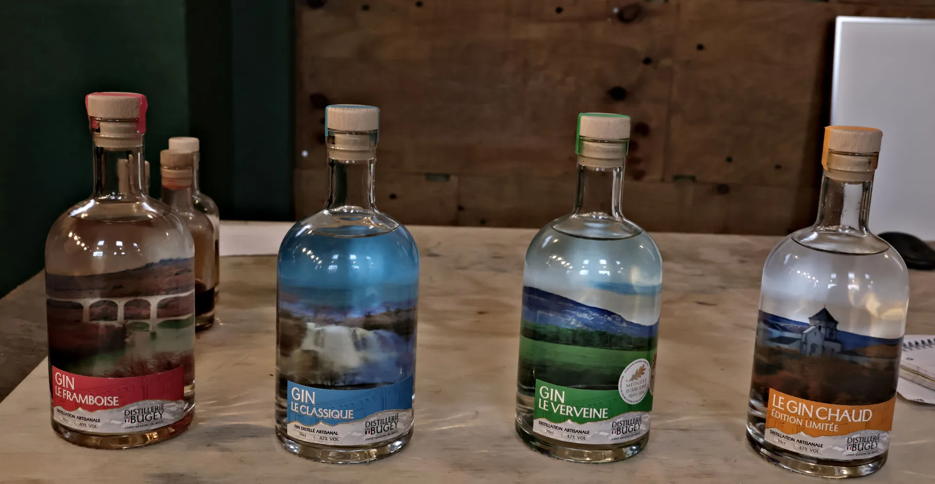 Bouteilles de gin artisanal à base de baies de genièvre locales à la Distillerie du Bugey.